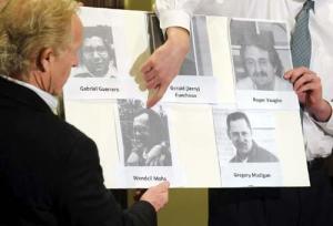 Attorneys Jeff Anderson, left, and Michael Finnegan point out a photo of Crosier Brother Wendell Mohs. The attorneys also displayed photos of other Crosier members involved in the settlement.