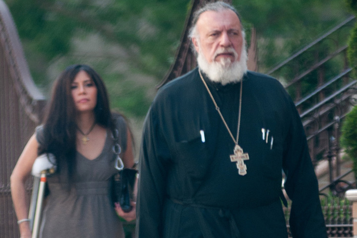 Father George Passias leaves St. Spyridon Greek Orthodox Church in 2013 with his mistress, Edith Bouzalas. Photo: JC Rice