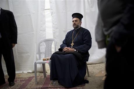 In this Monday, May 9, 2016 photo, Father Gabriel Naddaf who will light a torch this week in Israel's official independence day ceremony, arrives to the rehearsal for the upcoming ceremony in Jerusalem. Israel's decision to honor a controversial Greek Orthodox priest at its official independence day ceremony is driving a wedge in the country's tiny Christian Arab community as the government recognizes him for his crusade to encourage his followers to enlist in the Israeli military. (AP Photo/Oded Balilty)