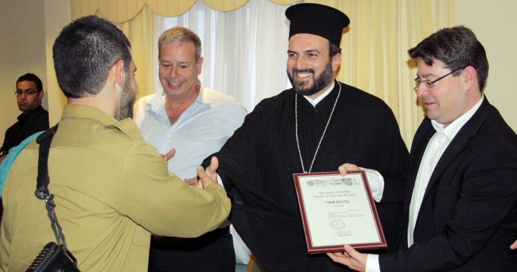 A Christian Arab soldier receiving a certificate of appreciation from Greek Orthodox priest Gabriel Naddaf during a 2013 event in Nazareth (Courtesy IDF Spokesperson’s Unit)