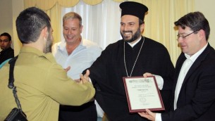 A Christian Arab soldier receiving a certificate of appreciation from Greek Orthodox priest Gabriel Naddaf during a 2013 event in Nazareth (photo credit: courtesy IDF Spokesperson’s Unit)