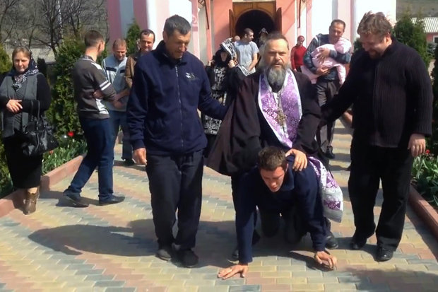 BURDEN: The plump priest rides the man like a donkey [CEN]