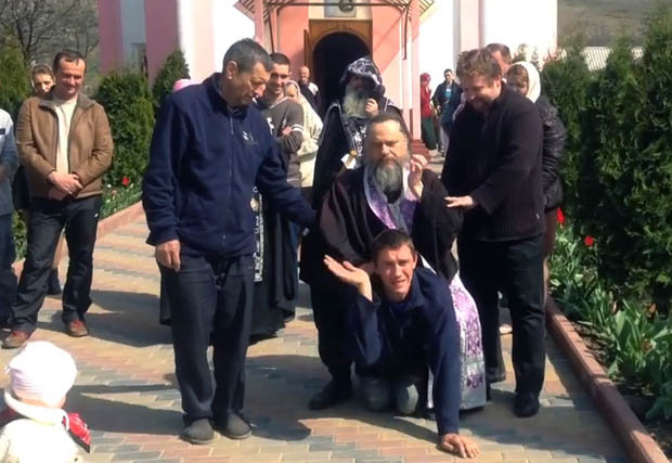 PAIN: The man pleads for help as villagers look on [CEN] 