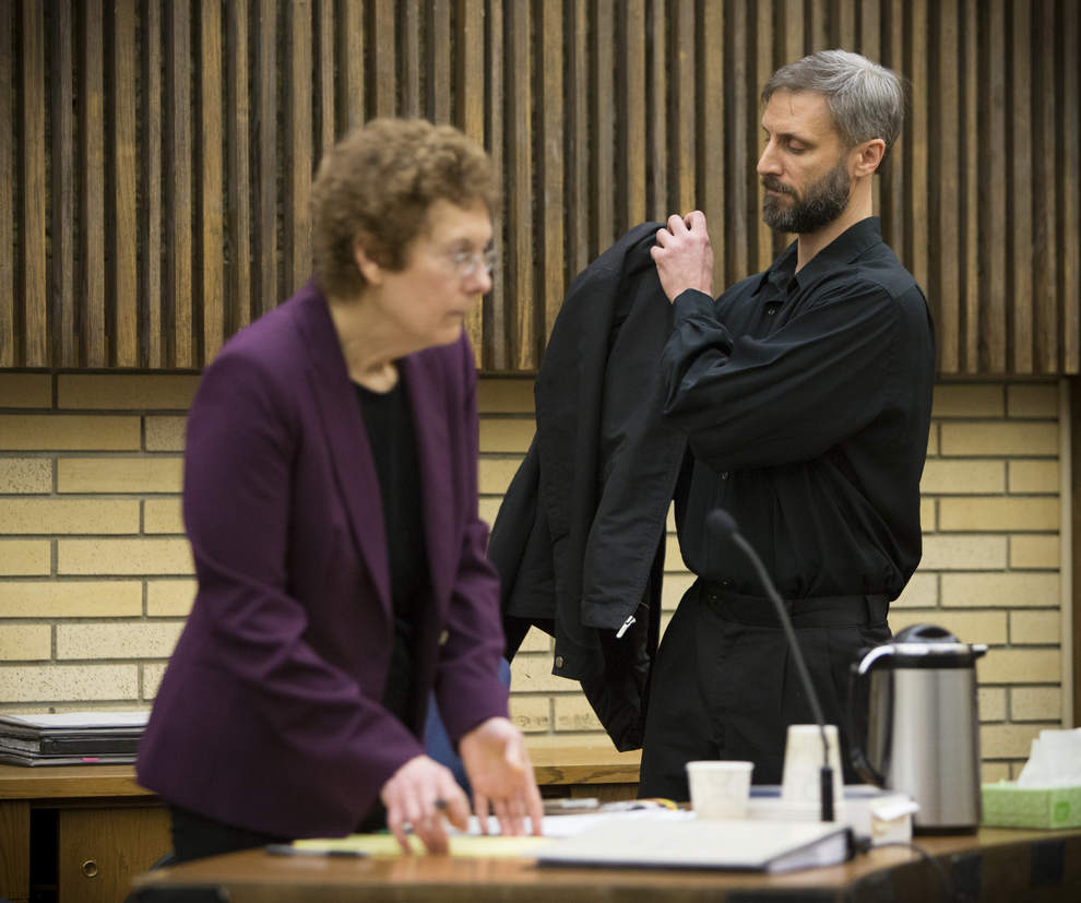 Eugene priest Daniel MacKay puts on his jacket after he was sentenced to jail Thursday by Lane County Circuit Court Judge Karrie K. McIntyre. McKay's attorney, Terri Wood stands nearby. (Andy Nelson/The Register-Guard)