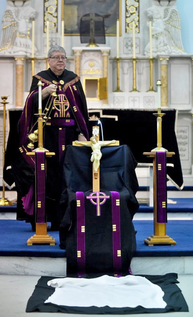 The Rev. Larry Jensen holds the figure of Jesus in a Good Friday rite at St. Joseph’s Maronite Church in Waterville on April 14. Jensen has been relieved of his priestly duties amid allegations of sexual abuse 15 years ago in Connecticut. Staff photo by Michael G. Seamans
