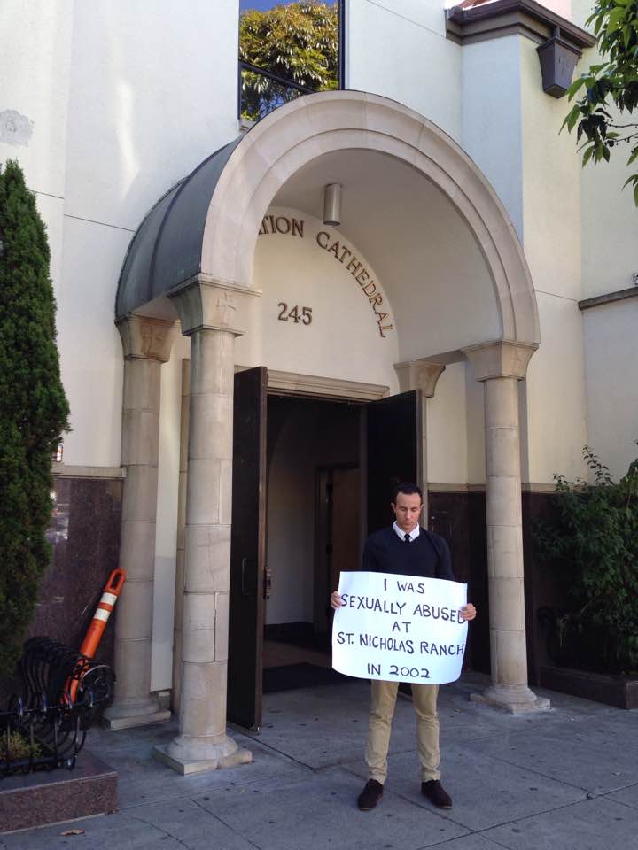 Mike standing outsite the headquarters of the Metropolis of San Francisco with his sign on Father's Day, 2017.
