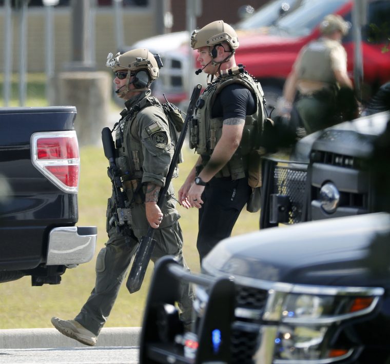 Police officers in tactical gear move through the scene at Santa Fe High School after a shooting on Friday, May 18, 2018, in Santa Fe, Texas. (Kevin M. Cox /The Galveston County Daily News via AP)
