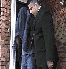 One of the two men (left) is led away.