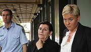 Tony Golossian's wife is taken to a police paddy wagon after a scuffle in the court. Photo: Kate Geraghty
