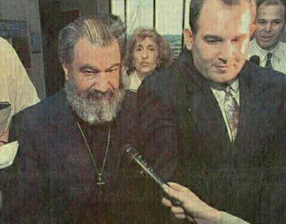 Photo/Glenn Russell: Suspended Greek Orthodox priest Emmanuel Koveos (left) is escorted from court by his wife Joanna (rear) and son John (right) after being sentenced to six months to five years in prison for lewd and lascivious conduct with a child.