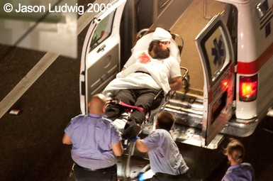 The Rev. Alexios Marakis, 29, of Crete, Greece, is carried to an ambulance after being beaten.
