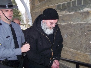 Phillip Ferrara, a priest at Our Lady of Solitude in Little Meadows, is led into Montrose District Court Friday for his arraignment on sex charges. STAFF PHOTO/STACI WILSON