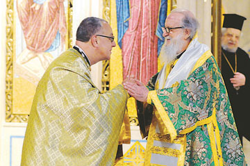   Fr. Anastasios Gounaris (L) is greeted by Archbishop Demetrios of America (C) as Bishop Philotheos looks on.