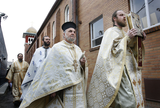 (Scott Sommerdorf | Tribune file photo) The Rev. Justin Havens (far right), pastor of Saints Peter and Paul Antiochian Orthodox Church, leads the procession around the church before entering for the consecration on Sunday, Jan. 24, 2010. The Rev. Michael Kouremetis follows behind Havens.